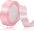 Roll of pink satin ribbon on a white background
